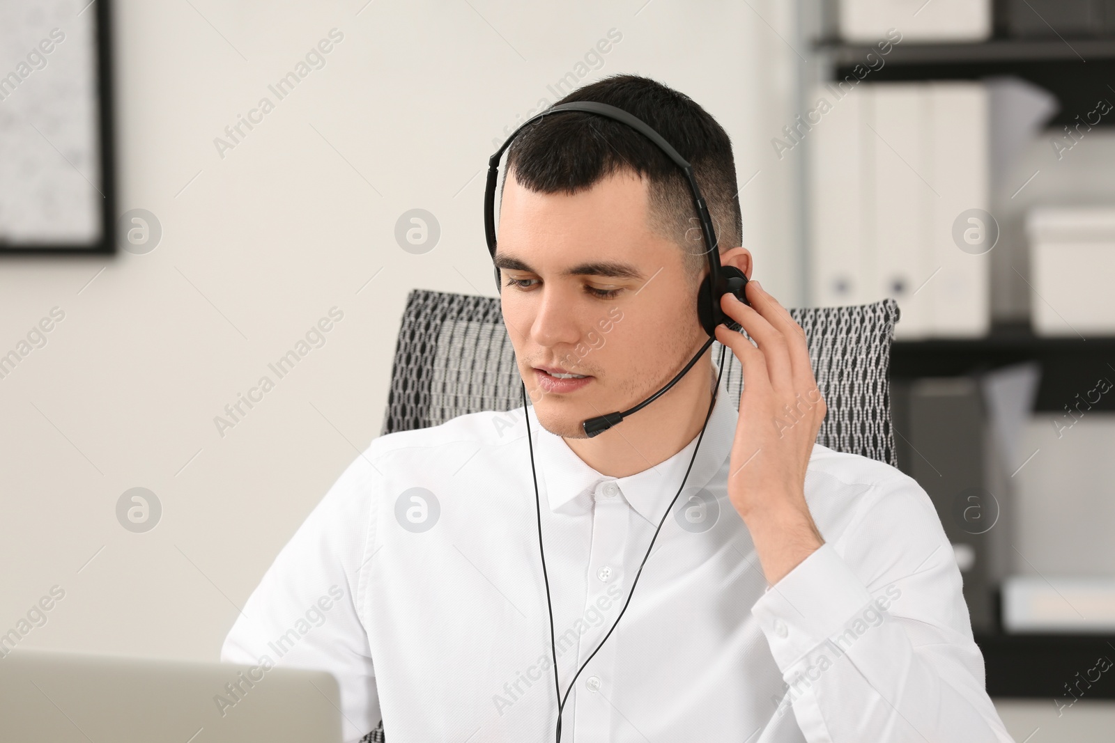 Photo of Hotline operator with headset working in office