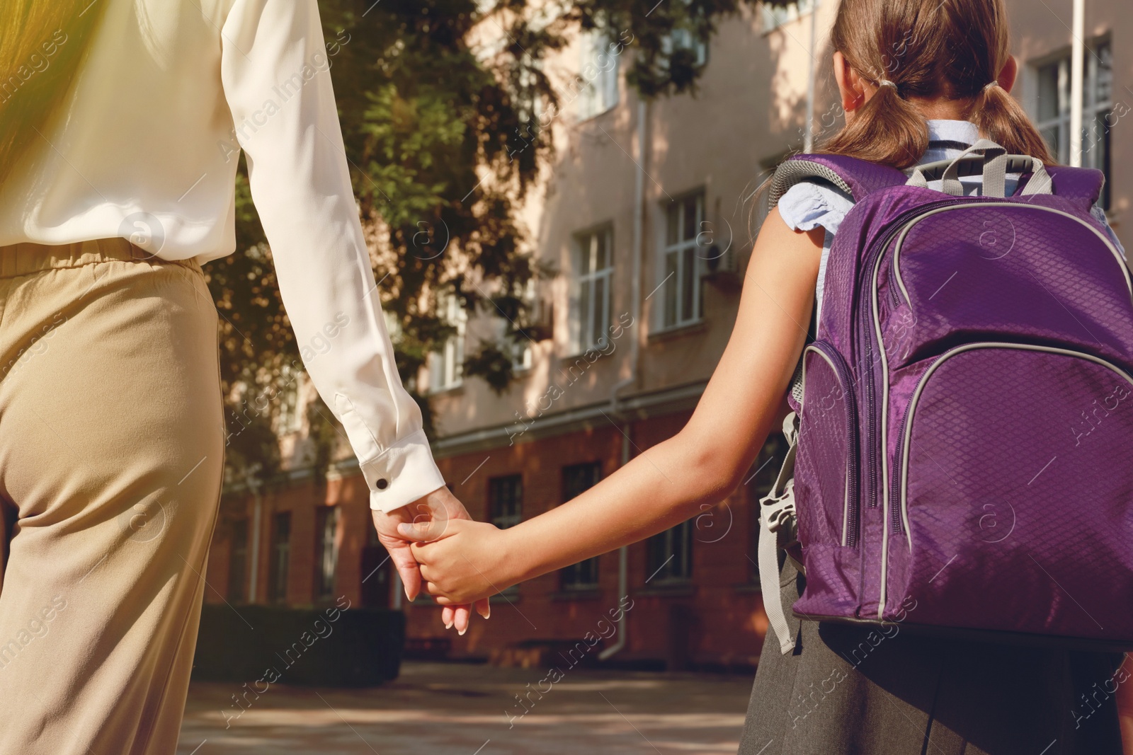 Image of Mother taking her daughter to school, closeup