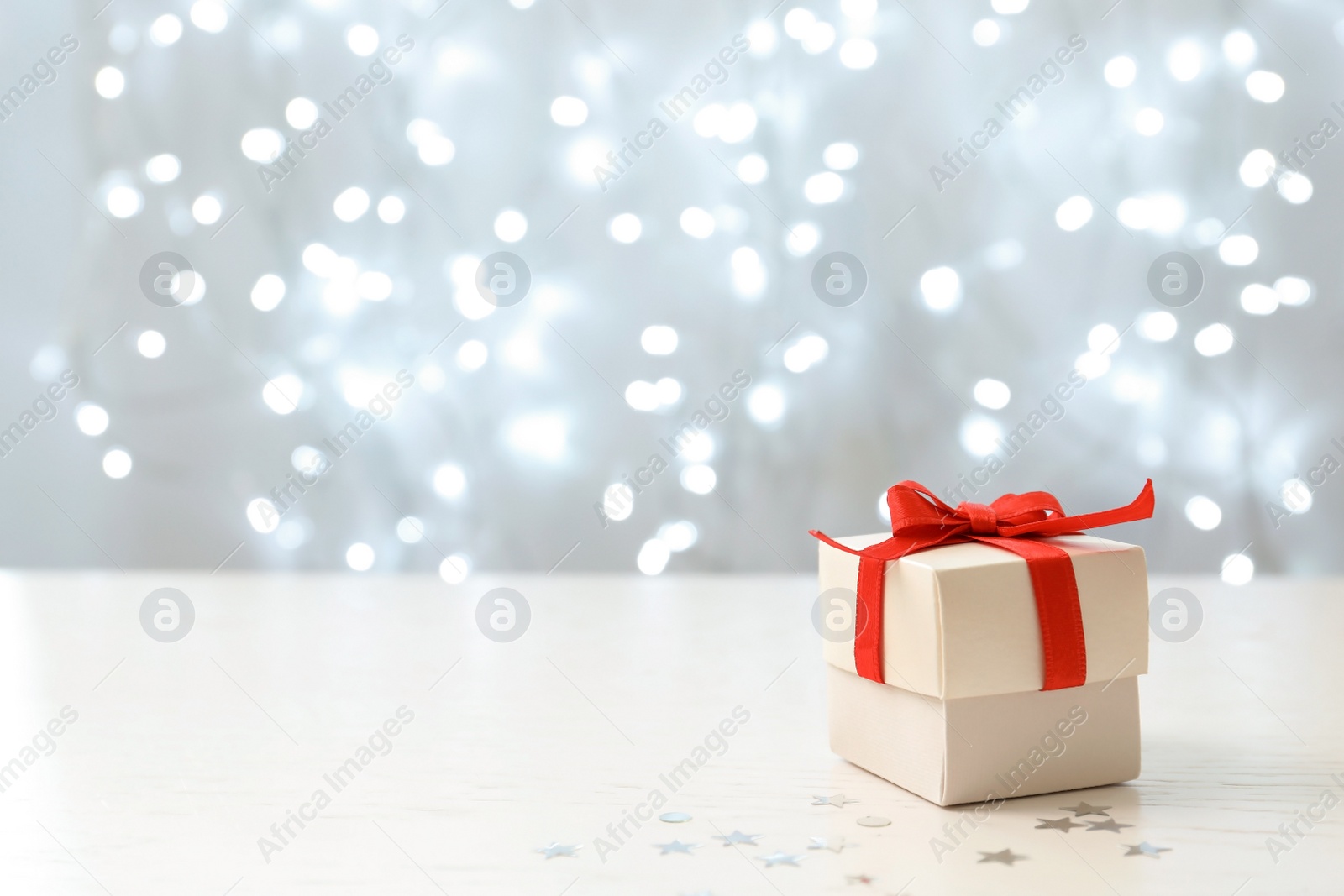 Photo of Christmas gift on table against blurred background