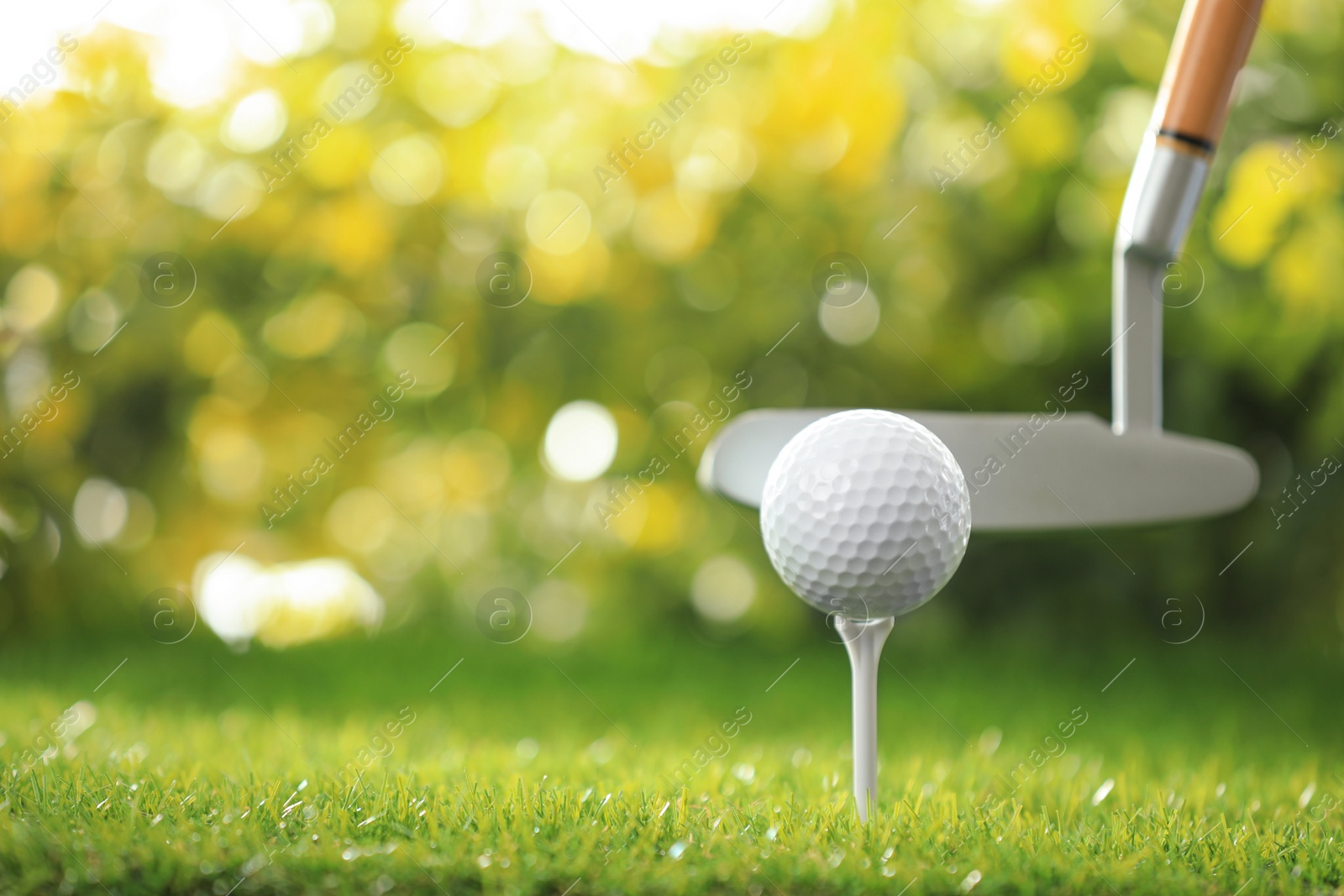 Photo of Hitting golf ball with club on green course