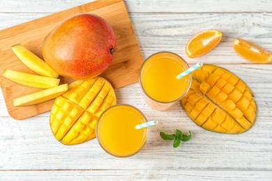 Photo of Tasty mango drink and fresh fruits on wooden table, top view