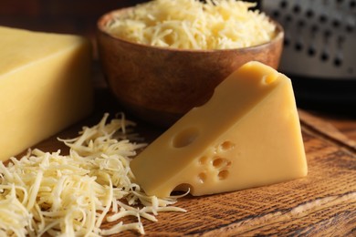 Photo of Grated and cut cheese on wooden board, closeup