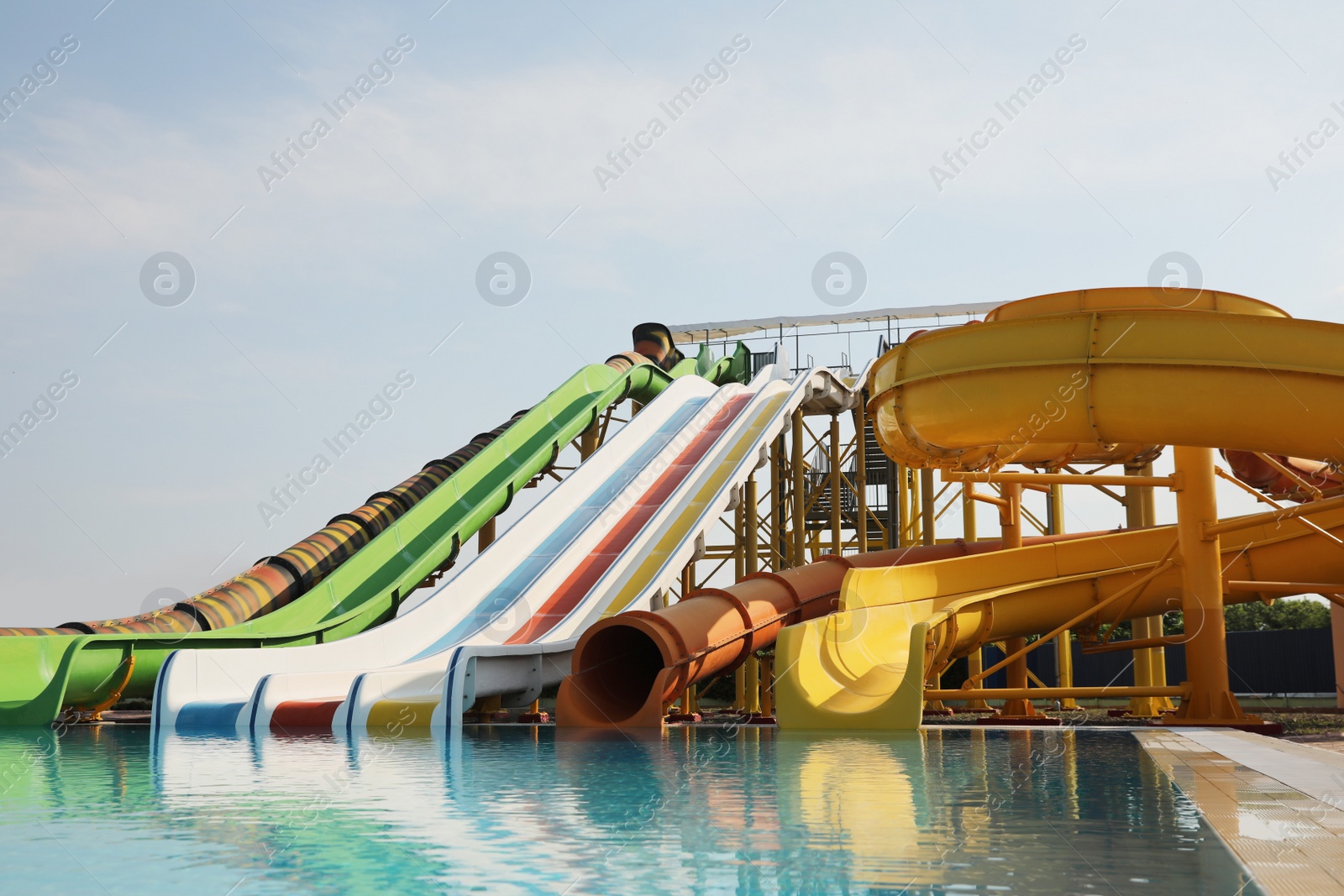 Photo of Beautiful view of water park with colorful slides and swimming pool on sunny day