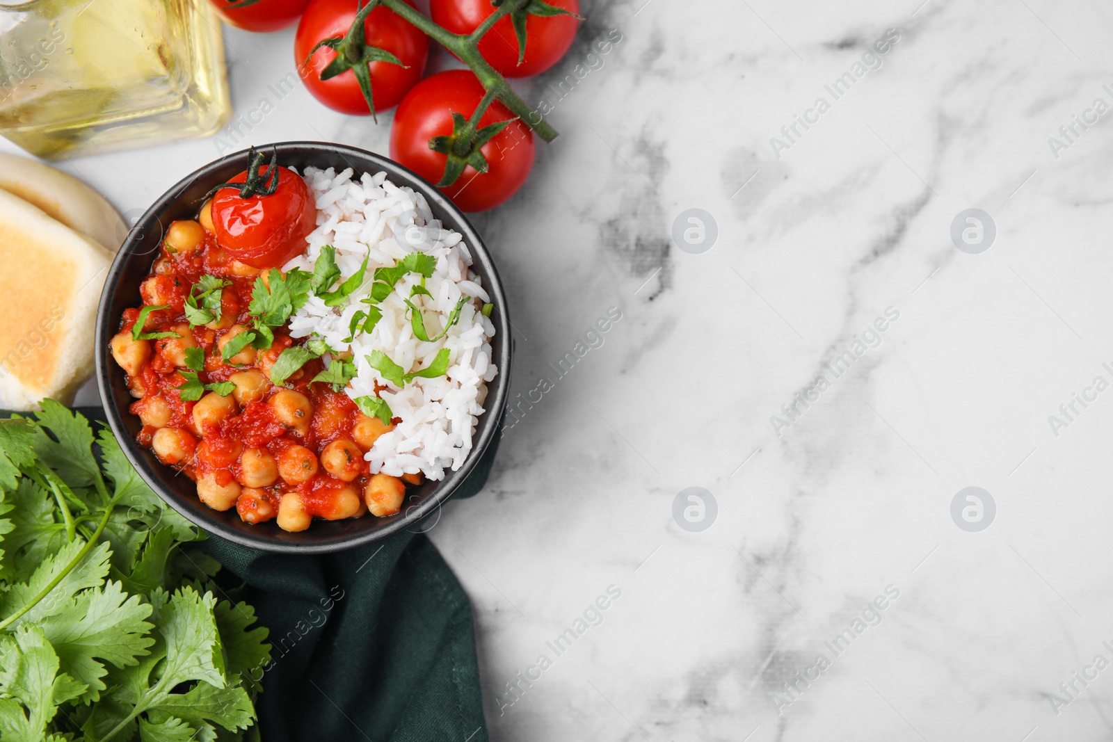 Photo of Delicious chickpea curry in bowl on white marble table, flat lay. Space for text