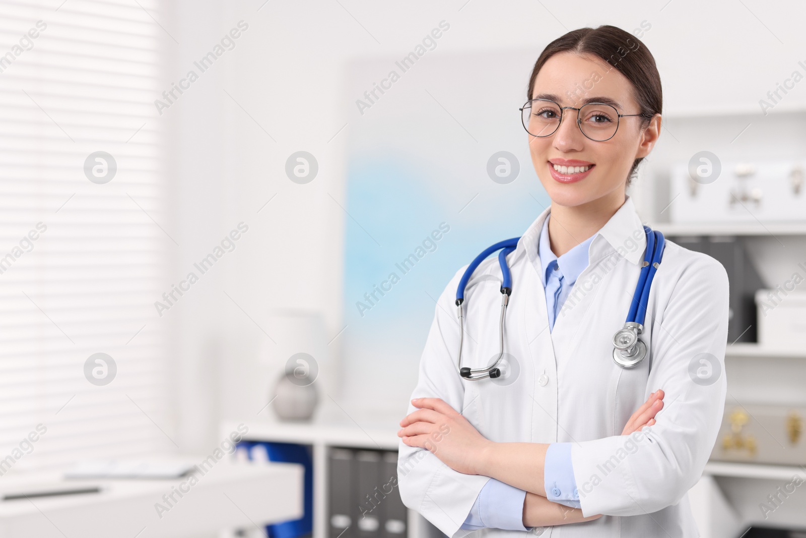 Photo of Medical consultant with glasses and stethoscope in clinic, space for text