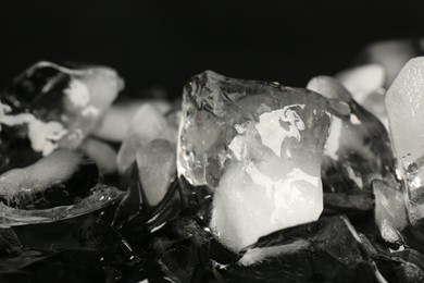 Photo of Pile of crushed ice on black mirror surface, closeup