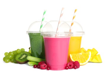 Photo of Plastic cups with delicious smoothies and ingredients on white background
