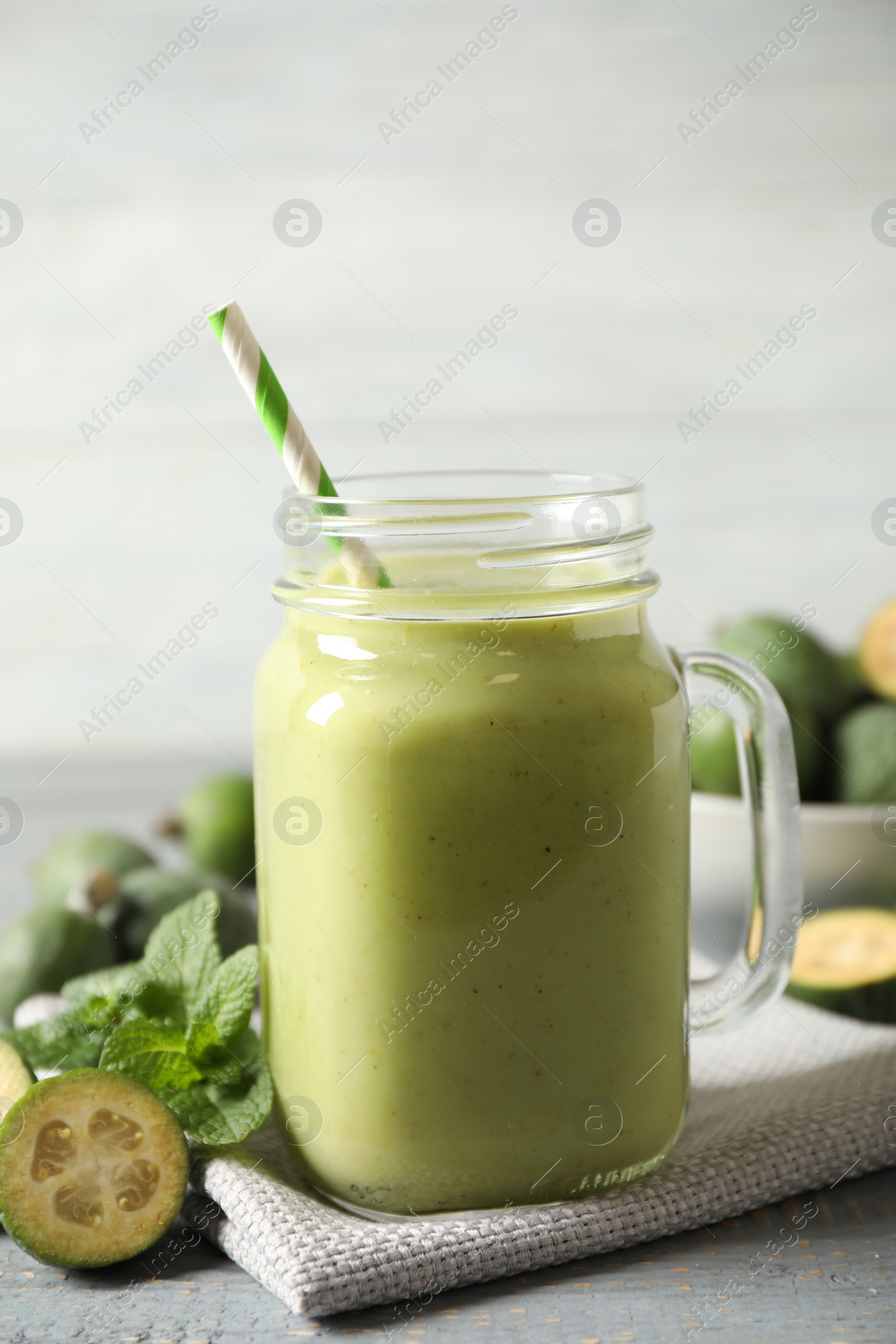 Photo of Fresh feijoa smoothie in mason jar on grey table