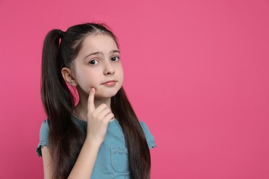 Photo of Pensive little girl on pink background, space for text. Thinking about answer to question