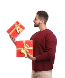 Photo of Happy young man holding Christmas gifts on white background