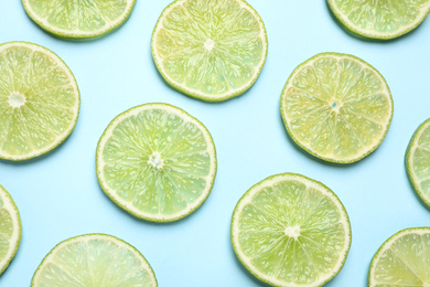 Fresh juicy lime slices on light blue background, flat lay