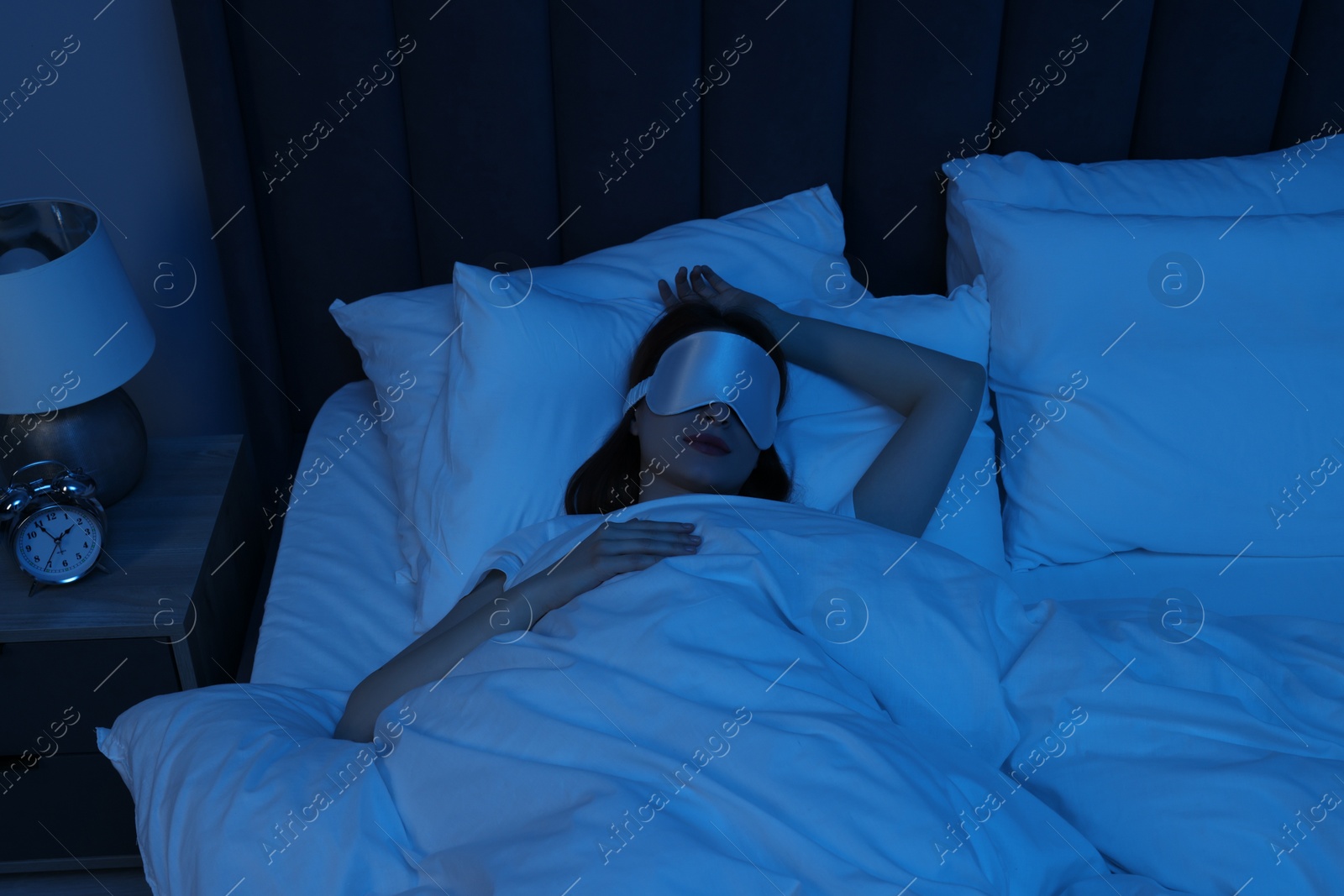 Photo of Woman with mask sleeping in bed at night