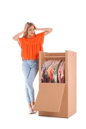 Young emotional woman near wardrobe box on white background