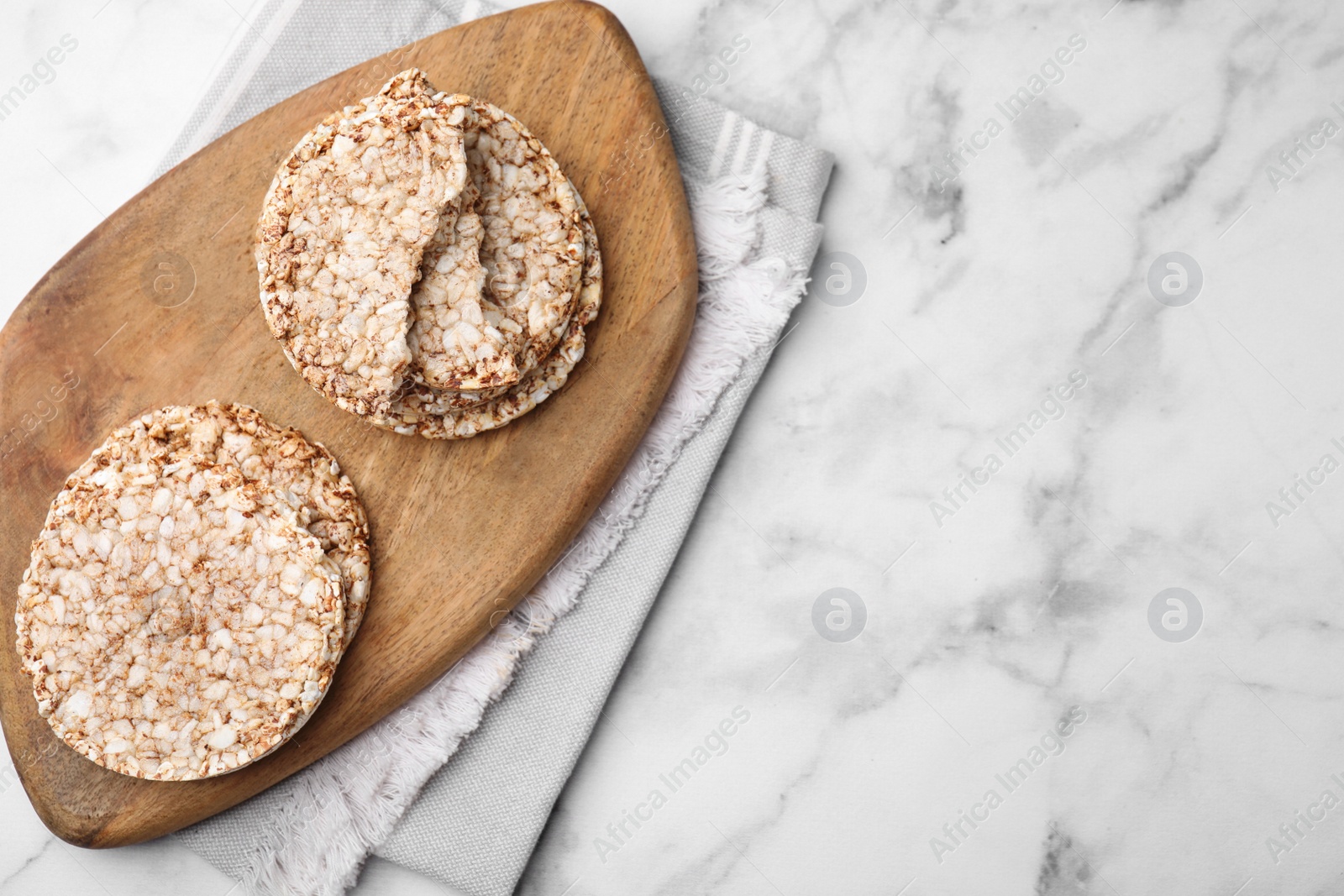 Photo of Crunchy buckwheat cakes on marble table, top view. Space for text