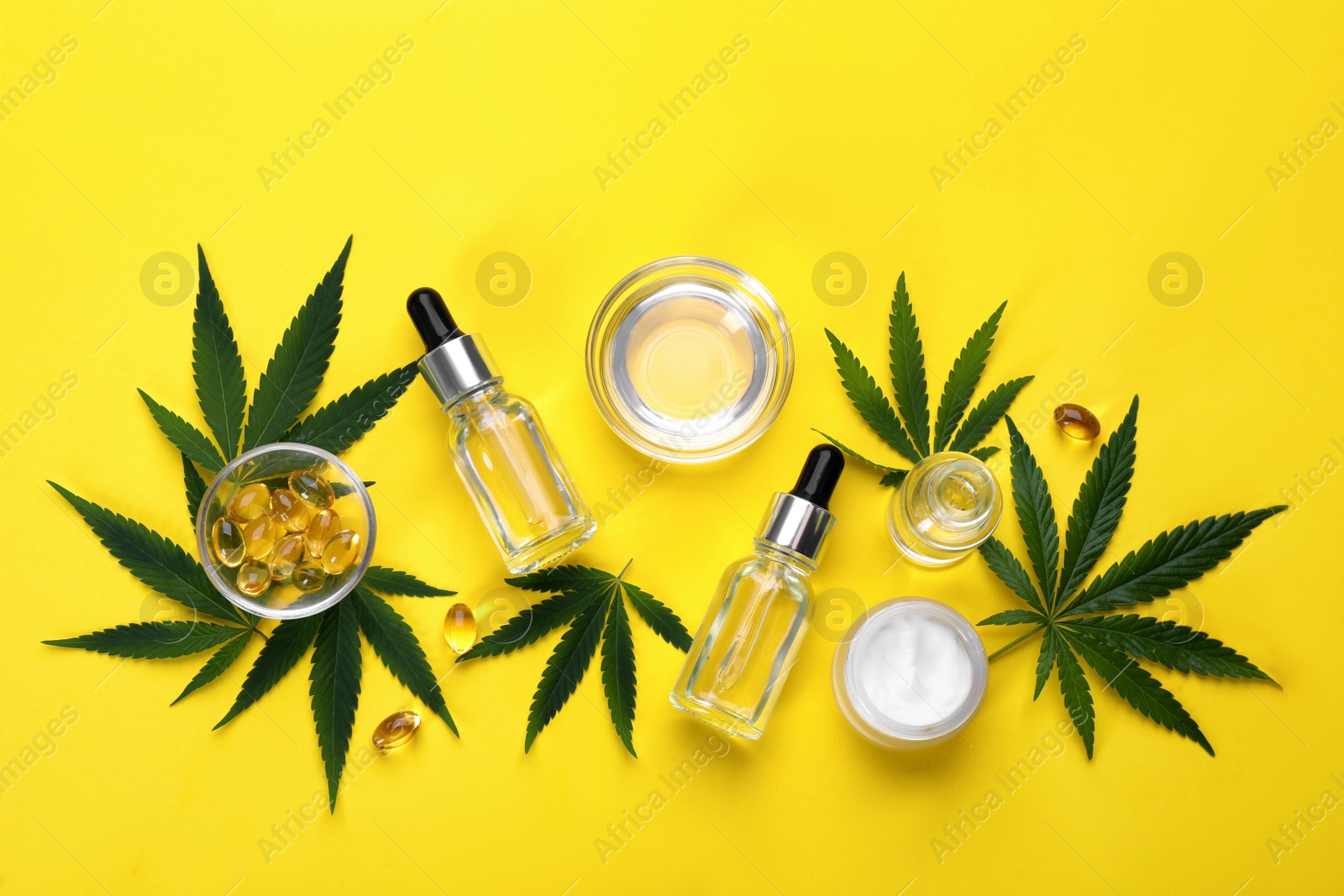 Photo of Flat lay composition with hemp leaves, CBD oil and THC tincture on yellow background