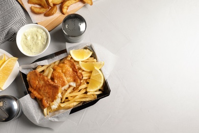 Photo of Container with British traditional fish and potato chips on table, top view. Space for text