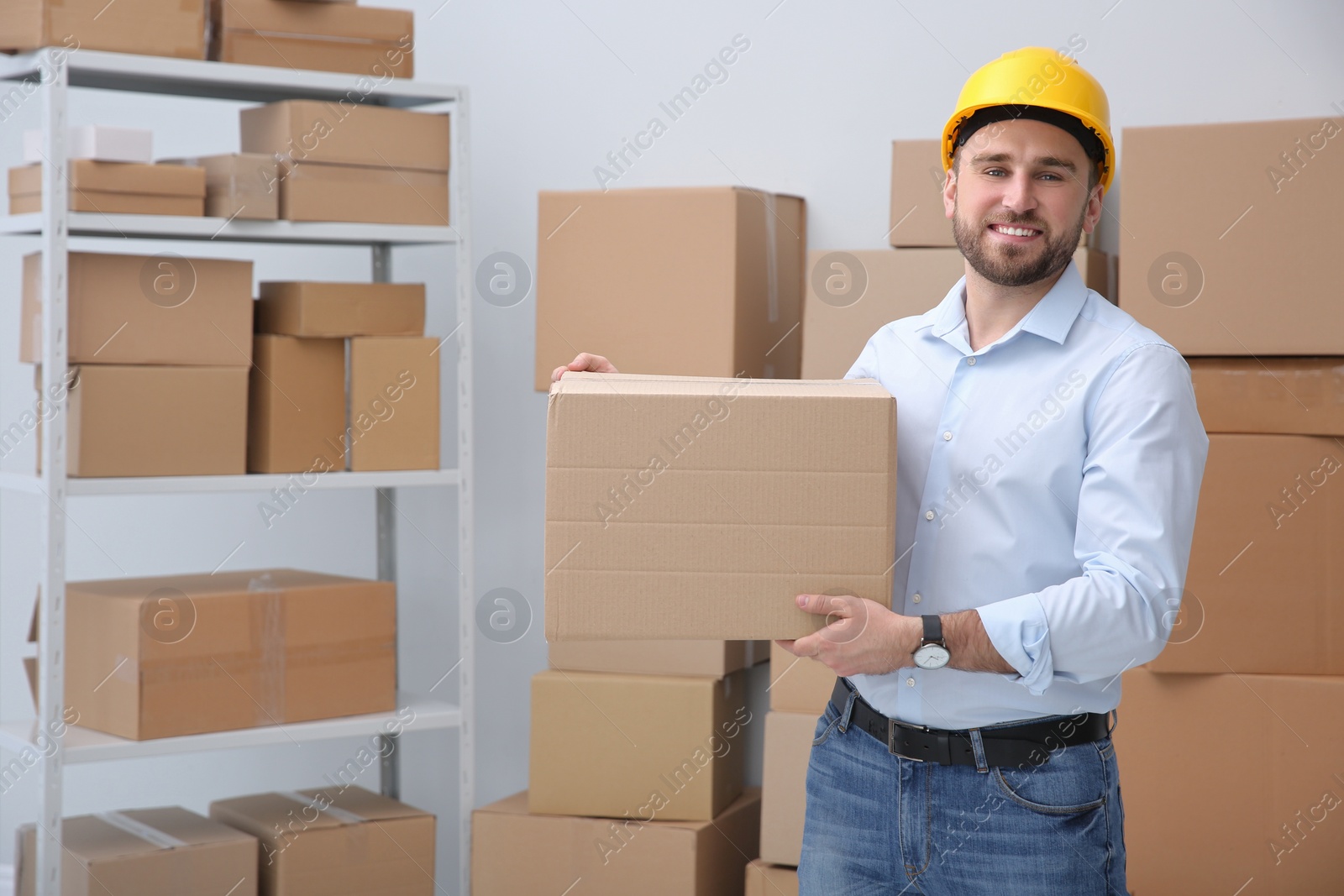 Photo of Young man with cardboard box at warehouse