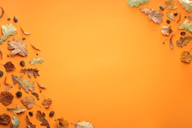 Autumn composition with dry leaves and cones on orange background, flat lay. Space for text