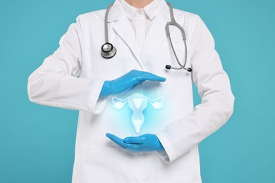 Doctor and illustration of female reproductive system on light blue background, closeup