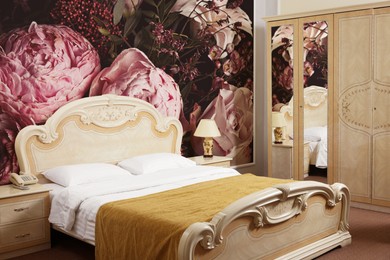Image of Stylish bedroom interior with luxury furniture and beautiful floral wallpapers