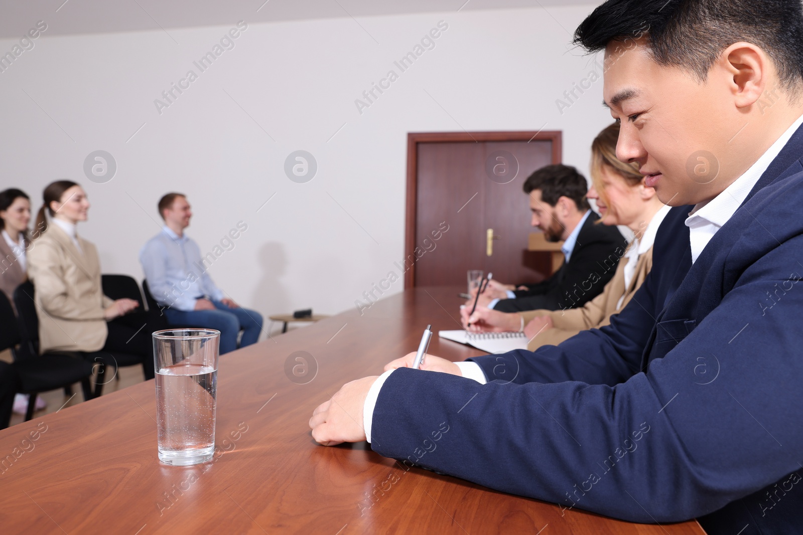 Photo of Business conference. People working at wooden table in meeting room