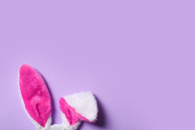 Photo of Funny Easter bunny ears on color background, top view with space for text