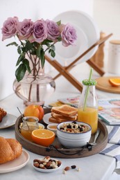 Photo of Tray with tasty breakfast on white table in morning