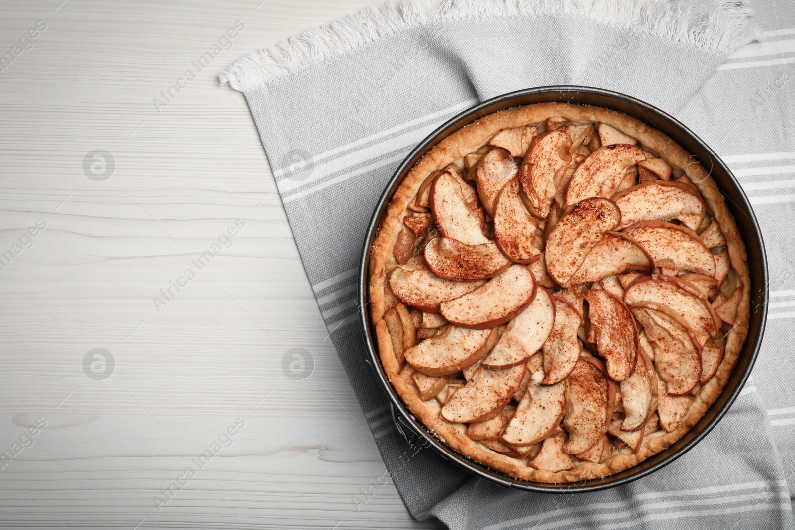 Photo of Delicious apple pie on white wooden table, top view. Space for text