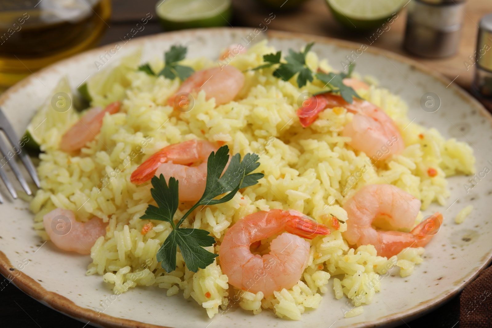 Photo of Delicious risotto with shrimps and parsley on table, closeup