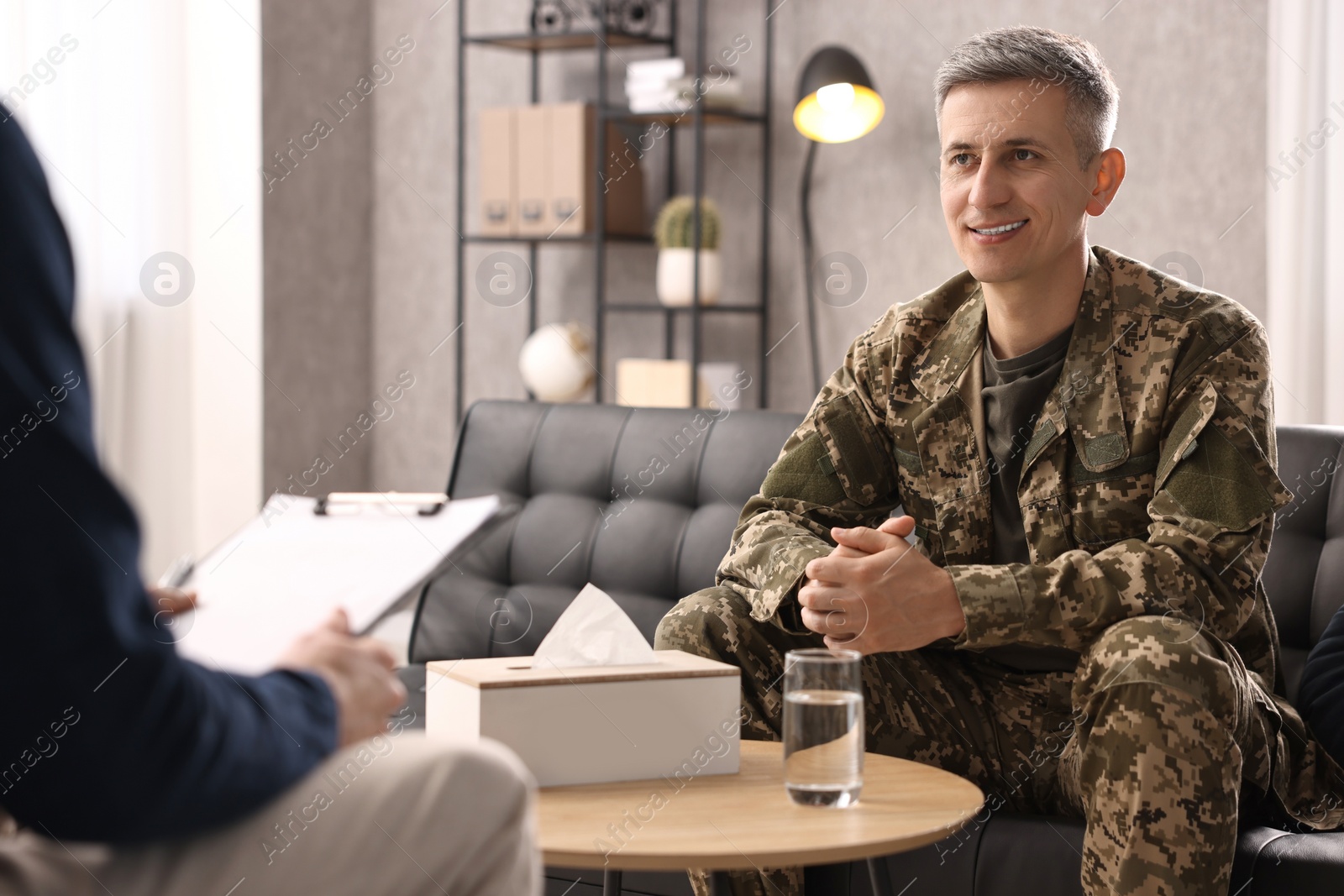 Photo of Professional psychotherapist working with military man in office