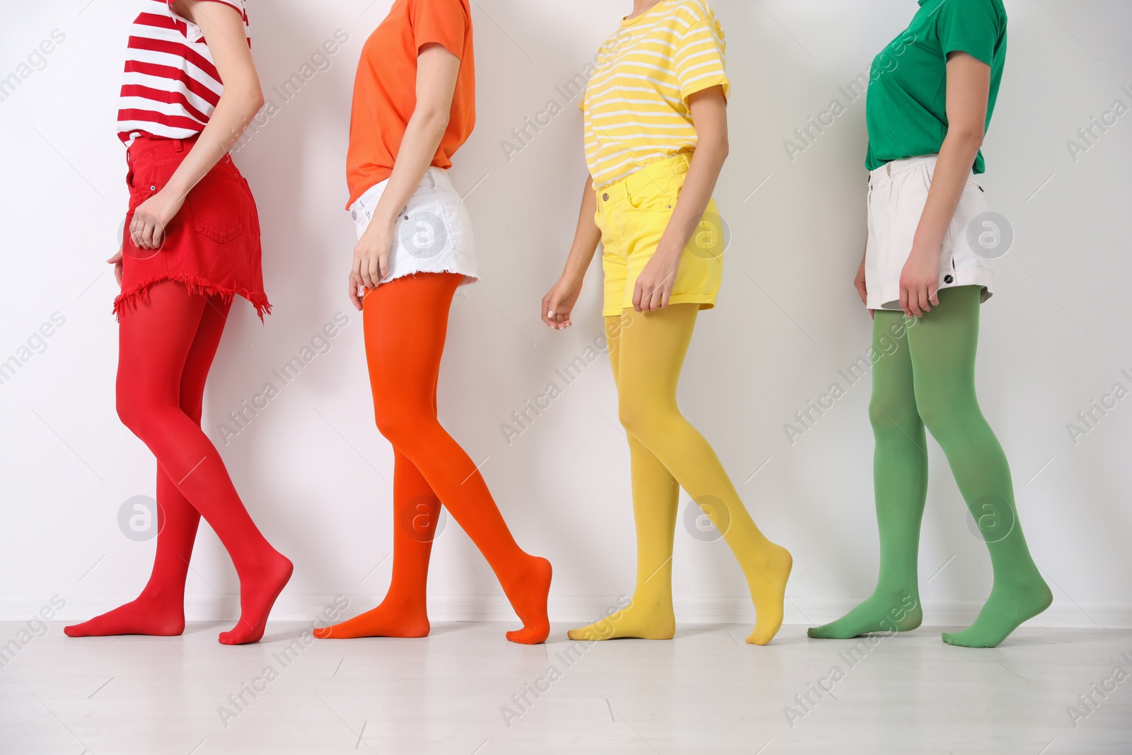 Photo of Women wearing bright tights near white wall, closeup
