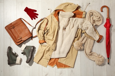 Set of stylish winter outfit on wooden background, flat lay