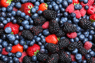 Photo of Mix of different ripe tasty berries as background, top view