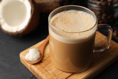 Photo of Delicious coffee with organic coconut oil on grey table