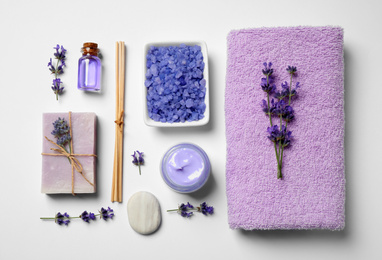 Cosmetic products and lavender flowers on white background, flat lay