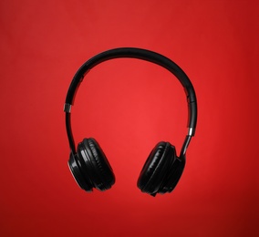 Photo of Stylish modern headphones with earmuffs on color background