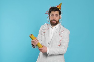 Photo of Confused man with party popper on light blue background