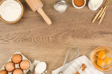 Photo of Flat lay composition with raw eggs and other ingredients on wooden background, space for text. Baking pie