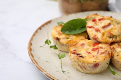 Photo of Freshly baked bacon and egg muffins with cheese on light table, closeup