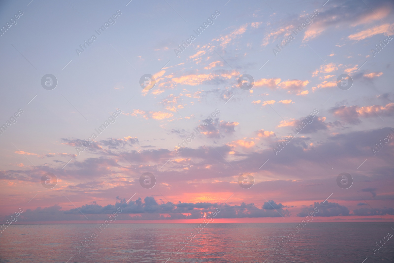 Photo of Picturesque view of sunset with clouds over sea