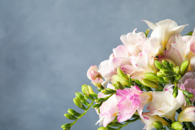 Photo of Beautiful pink freesia flowers on light blue background, closeup. Space for text