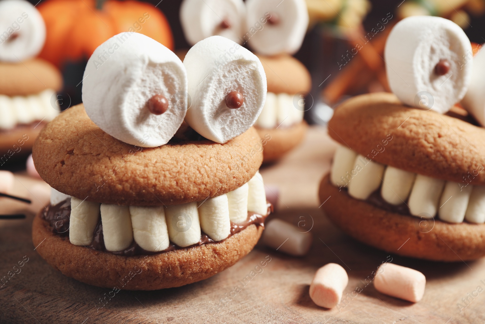 Photo of Delicious Halloween themed desserts on wooden table, closeup