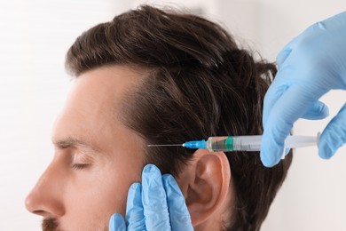 Photo of Trichologist giving injection to patient in clinic, closeup