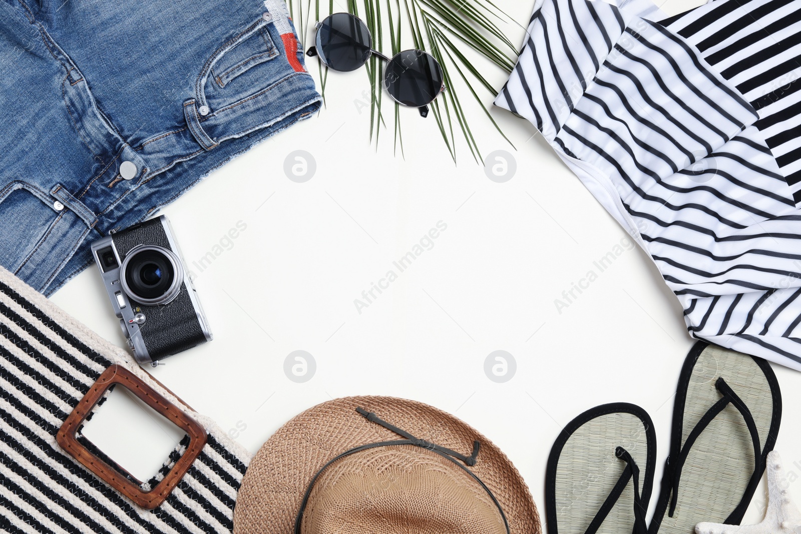 Photo of Frame made of stylish beach accessories on light background, flat lay. Space for text