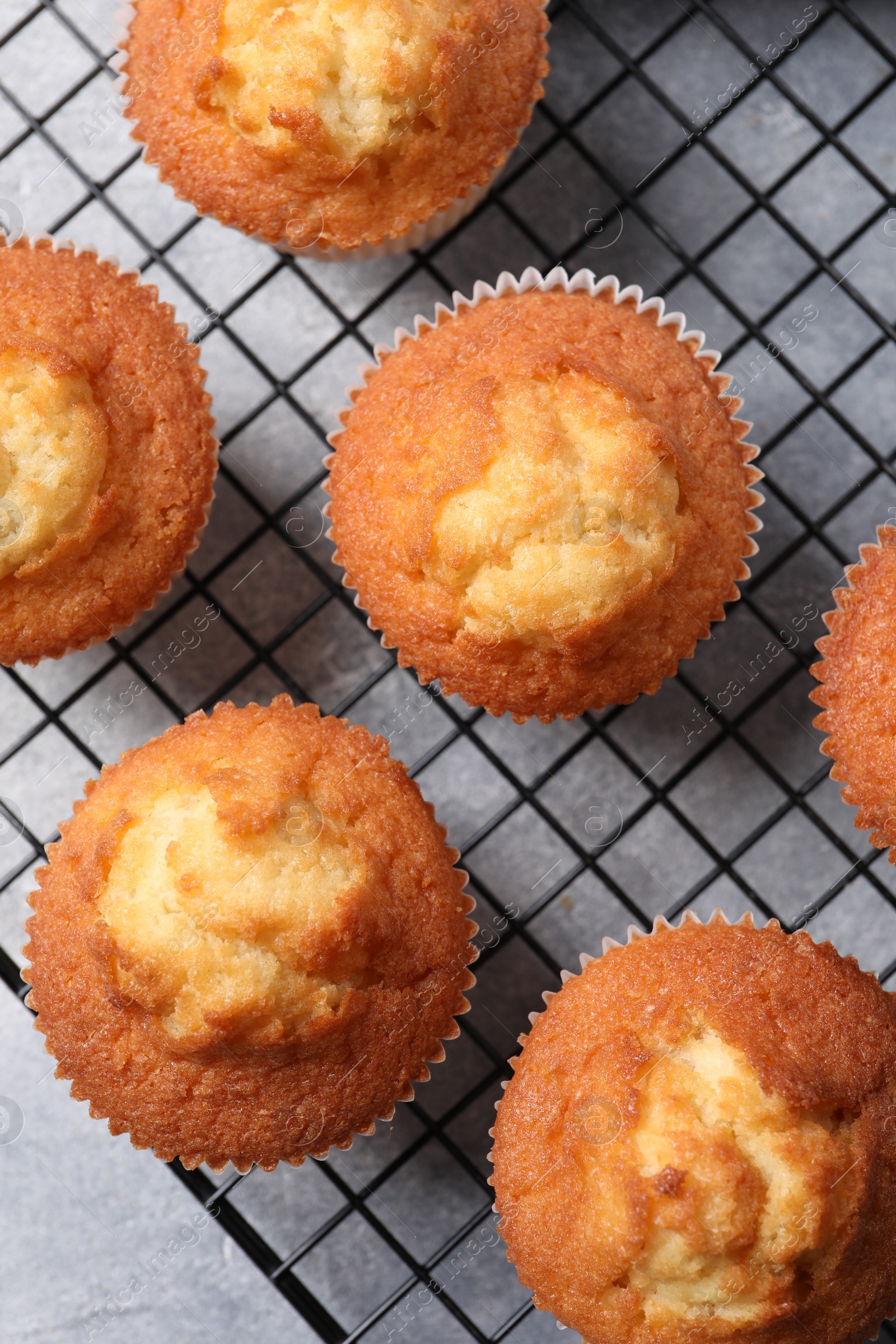 Photo of Delicious sweet muffins on grey textured table, top view