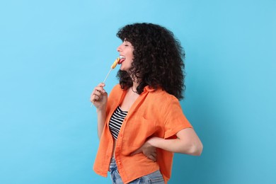 Photo of Beautiful woman with lollipop on light blue background