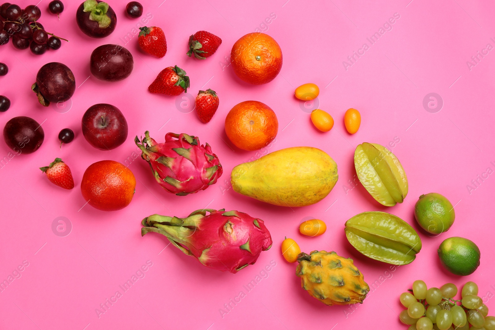 Photo of Many different delicious exotic fruits on pink background, flat lay