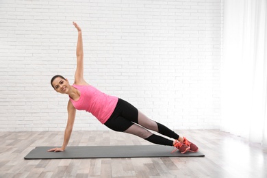 Photo of Young beautiful woman practicing yoga at home. Workout and fitness