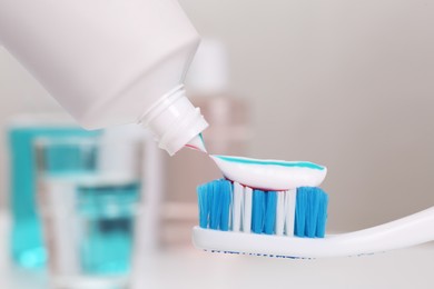 Photo of Applying paste on toothbrush near mouthwash, closeup