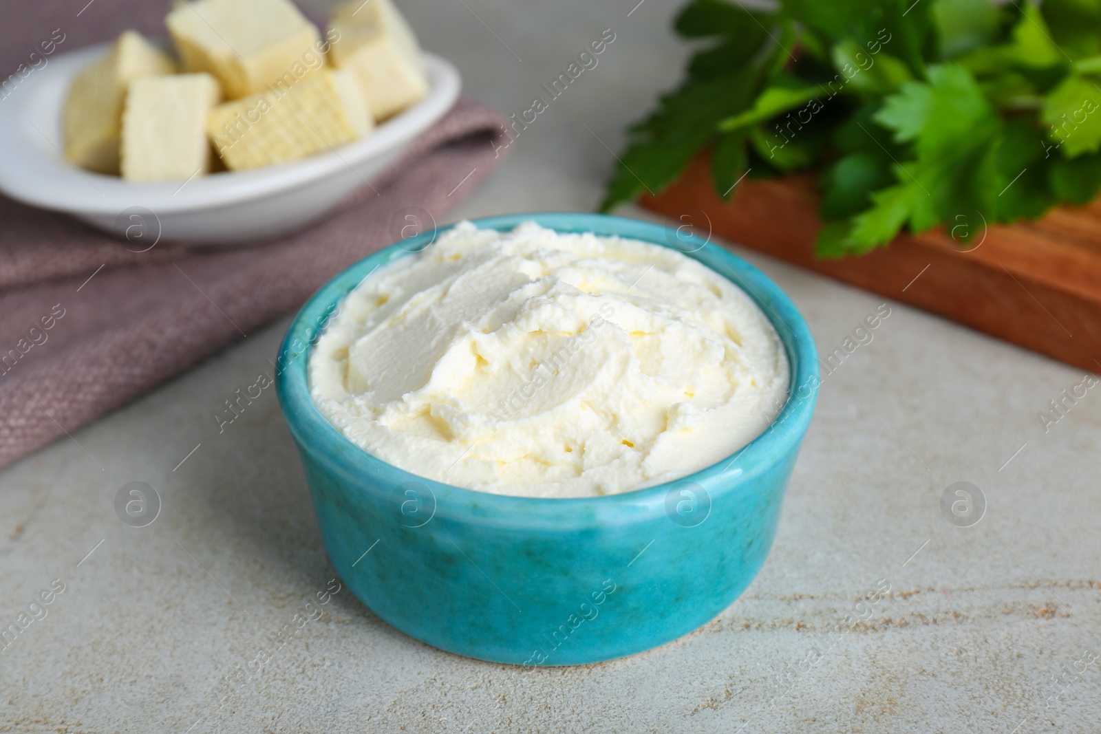 Photo of Delicious tofu cream cheese in bowl on light table, closeup